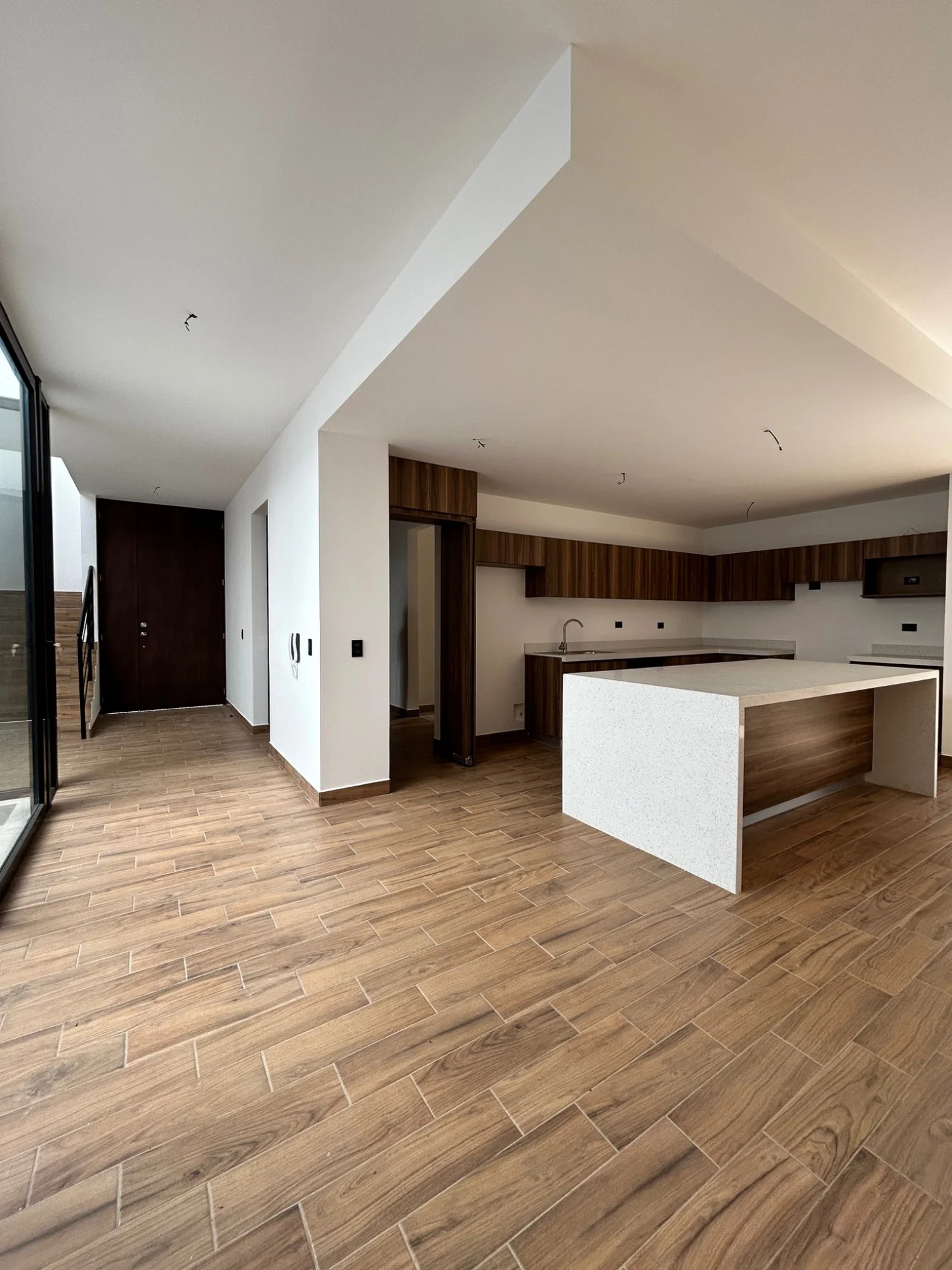 Cocina abierta con isla y piso de apariencia madera